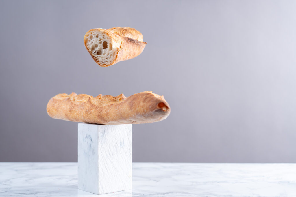 baguette de pain coupée en deux. La rencontre Boulangerie - pâtisserie